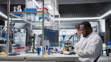 Laboratory scientist using computer to process DNA patient data, communicating results to coworkers. Lab expert uses PC to do lab genetic analysis diagnostics, sharing data with colleagues, camera A video