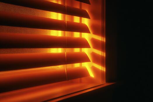 Golden light shining through window blinds at dusk photo