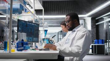 laboratorio bioinformática científico evalúa genético marcadores utilizando ordenador personal, analizando muestra propiedades. hombre estudios adn hebra cartografía y químico solución componentes utilizando programa en computadora, cámara un video