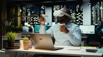 svart manlig arbetstagare använder sig av vr glasögon och gadgetar till förslag en projekt planen, prognostisering framskrivningar och dokumentera risk bedömning resultat. organisering uppgifter för företag mål. kamera a. video