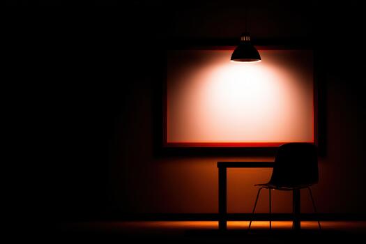Empty room with a table and a chair under a light photo