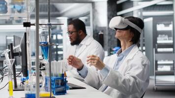 laboratorio specialista indossare vr cuffia attrezzatura utilizzando chimico fluidi per esperimenti. chimico usi virtuale la realtà dispositivo per simulare utilizzando soluzione laboratorio cristalleria a postazione di lavoro, telecamera B video