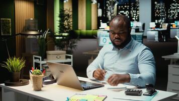 nero attività commerciale esperto impegnato nel grafia Appunti per un' presentazione, estrazione essenziale dati a partire dal finanza documenti e fabbricazione un' sommario con aggiornamenti per attività commerciale obiettivi e compiti. telecamera un. video