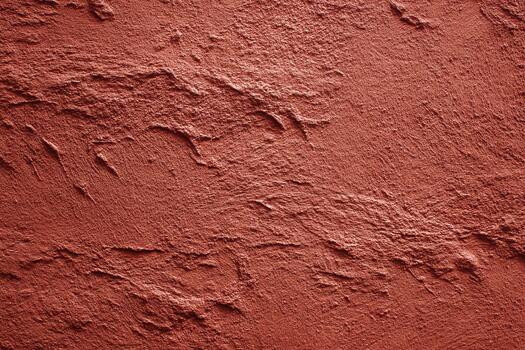 Textured red surface resembling natural soil or clay photo