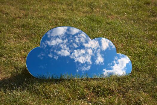 Reflective cloud shape resting on green grass field photo