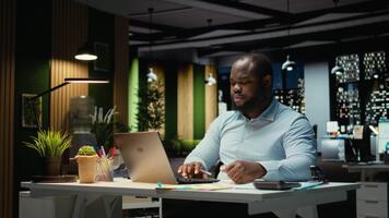 svart kontor anställd ripping en bit av papper efter framställning en misstag, startar om hans uppgift i ilska och rivning upp de sida ark. missnöje kille skrivningar en stavfel medan transkribera. kamera a. video