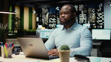 svart person korrekturläsning och faktum kontroll finansiell tal, granskning arkiveras filer efter timmar i de strategi rum. utvärdera data på rapporter, forska och organisering dagordning. kamera a. video