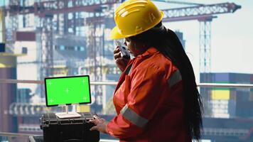 Isolated screen tablet used by drilling rig expert to monitor systems, talking in handheld radio. Offshore platform technician using walkie talkie, calibrating gear with chroma key device, camera B video
