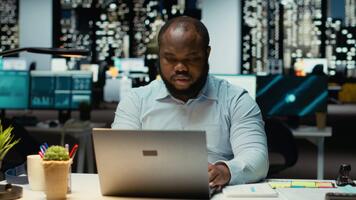 attività commerciale direttore riflette su un' problema in ritardo a notte dopo ore, metodico pianificazione e creativo contemplazione per guida lui verso un' decisione quello saldi razionalità con positività. telecamera b. video