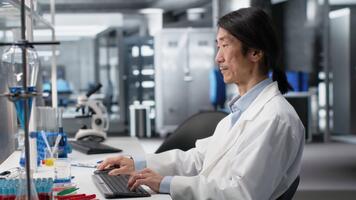 laboratoire scientifique à la recherche pour génomique variation dans génétique Marqueurs en utilisant pc. gai homme identifiant ADN mutations, cartographie génomique une analyse en utilisant programme sur ordinateur, caméra b video