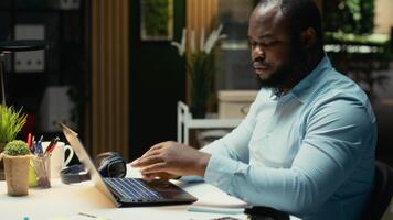 Black business expert engaged in handwriting notes for a presentation, extracting essential data from finance documents and making a summary with updates for business goals and tasks. Camera B. video