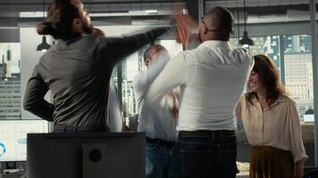 azienda dipendenti unendo mani e applauso loro gruppo successo, progetto pianificazione e dati analitica. colleghi messa a fuoco su documentazione e risorsa assegnazione per raggiungere progresso. telecamera b. video