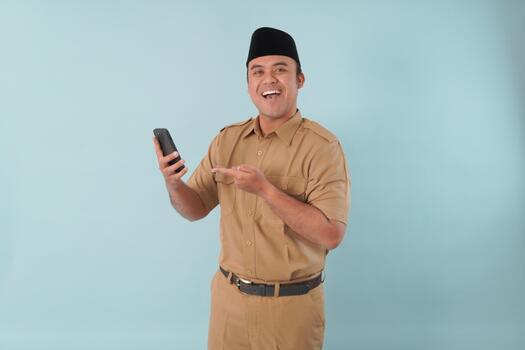 Smiling government worker with khaki uniform He is doing call while pointing to his smartphone PNS, ASN, civil servant concept, photo
