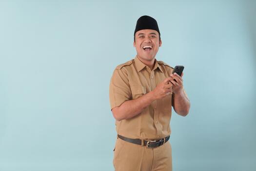 Smiling government worker with khaki uniform He is doing call while pointing to his smartphone PNS, ASN civil servant, concept photo