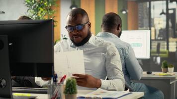 professionell företag människor analysera dokument och grafer för risk bedömning. olika arbete team samarbetar på Rapportera skrivande, prognostisering och prestanda metrik i kontor. kamera b. video