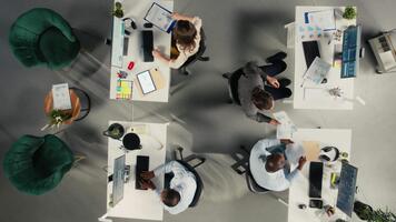 topo baixa Visão ampliação dentro do colegas de trabalho colaborar em relatório escrevendo e dados visualização. a equipe focos em desempenho Objetivos, gestão estratégia e eficiente relatório compartilhamento. Câmera uma. video