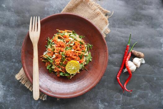 Trancam is a traditional salad from Java, Indonesia made from fresh vegetables such as cucumber, basil, long beans, and white cabbage, which are cut into pieces and mixed with grated coconut with photo