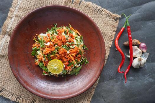 Trancam is a traditional salad from Java, Indonesia made from fresh vegetables such as cucumber, basil, long beans, and which are cut into pieces and mixed with grated coconut with spices. photo