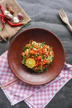 Trancam is a traditional salad from Java, Indonesia made from fresh vegetables such as cucumber, long beans, and white cabbage, which are cut into pieces and mixed with grated coconut with spices. photo