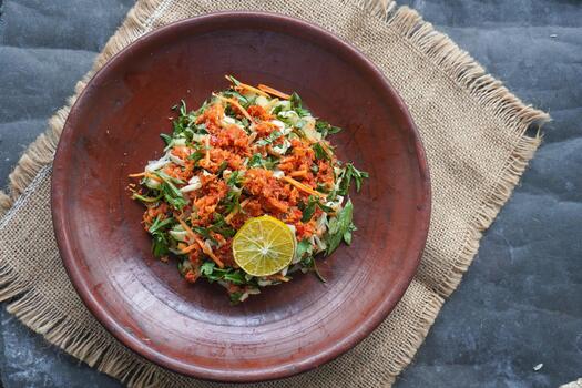 Trancam is a traditional salad from Java, Indonesia made from fresh vegetables such as cucumber, basil, long beans, and white cabbage, photo