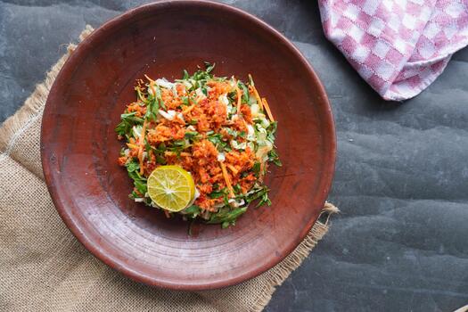 Trancam is a traditional salad from Java, Indonesia made from fresh vegetables such as cucumber, basil, long beans, and white cabbage, which are cut into pieces and mixed with grated coconut photo