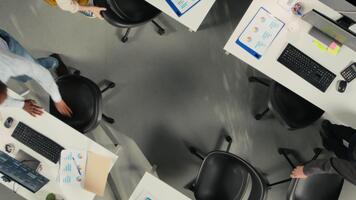 parte superior abajo ver enfocar fuera de empleados revisión datos visualización a reunirse objetivos para progreso. colegas compartir analítica en un moderno corporativo ambiente a mejorar pronóstico cámara una. video