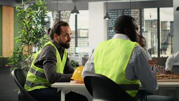 Time lapse of real estate developers and architects in workspace reviewing blueprints and 3D models. Development team discussing urban planning and property investment. Camera B. video