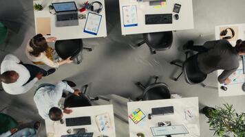 topo baixa Visão ampliação dentro do o negócio pessoas usando computadores dentro área de trabalho, análises projeções e relatórios. equipe focos em o negócio informações, intuições e alvos debaixo executivo gerenciamento. Câmera uma. video