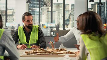 utvecklare och arkitekter arbetssätt på verklig egendom investering planen. företag team analyser fast egendom data, hus ritningar och marknadsföra trender till optimera landa förvärv och projekt. kamera b. video