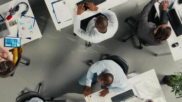 parte superior abajo ver enfocar fuera de negocio personal en moderno oficina compartiendo perspectivas y informes, equipo se enfoca en datos visualización para eficiente recurso asignación. empresa administración. cámara una. video