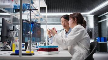 multietnisk team av klinisk laboratorium teknologer granskning blod data under diagnostik studie. olika medarbetare validerar sangvinisk vätskor prov resultat, kamera en video