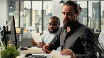 medarbetare grupp samarbeta på Rapportera skrivning och data visualisering, och analys. de team fokuserar på prestanda mål, förvaltning strategi och effektiv Rapportera delning. kamera b. video