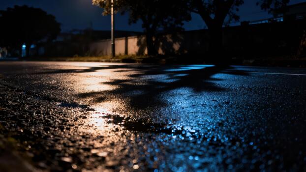 Street pavement surface displays shimmering reflections from artificial light sources after rainfall at night photo
