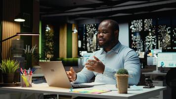 afrikansk amerikan kille vinka på webb konferens med aktieägare, delta en avlägsen chatt på internet från kontor skrivbord. anställd nätverk, förhandlings med verkställande styrelse. kamera a. video