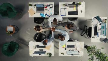 topo baixa Visão do o negócio pessoas a comemorar trabalho em equipe com arquivos e diagramas dentro colaborativo escritório. trabalhos equipe alinha estratégia e gestão com intuições para melhorado desempenho. Câmera uma. video