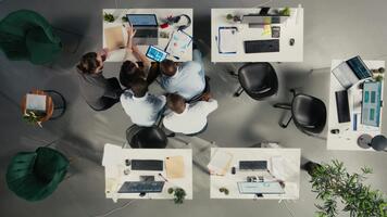 topo baixa Visão do diverso profissionais colaborando em o negócio análise, revendo visual dados e projeções para Apoio, suporte estratégia e progresso dentro multinacional empresa. Câmera uma. video