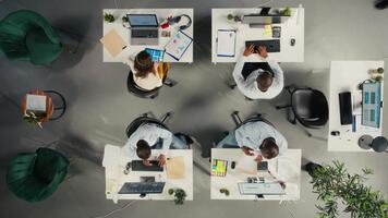 parte superior abajo ver de compañeros de trabajo comprometido en consultante y reporte compartiendo a oficina. profesional equipo comentarios visual datos y documentos a mejorar negocio estrategia y actuación objetivos. cámara una. video