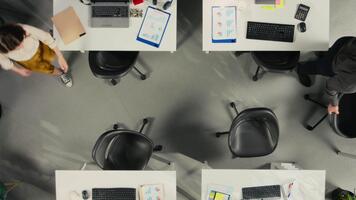 topp ner se zoom ut av personal i kontor diskutera företag strategi och marknadsföra forskning. olika medarbetare utvärdera dokument och diagram till justera mål, mål och prestanda metrik. kamera a. video