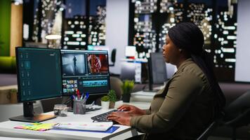 femmina specialista editore Lavorando nel produzione industria a agenzia ufficio, fare colore classificazione e la creazione di un' montaggio su doppio monitor. creativo processi con multimedia Tech Strumenti. telecamera b. video