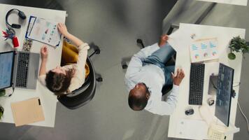 topo baixa Visão ampliação Fora do profissional pessoas analisando documentos e gráficos para risco avaliação. diverso trabalhos equipe colabora em relatório escrevendo e previsão dentro escritório. Câmera uma. video