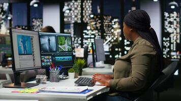 squadra di multietnico videografi la modifica sparare nel inviare produzione, utilizzando moderno Tech e la modifica Software per un' creativo progetto. moderno spazio di lavoro con doppio monitor. telecamera b. video