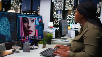 Preto gráfico desenhador usa ai neural redes para retocada imagens, profundo Aprendendo e edição cor para Novo materiais. profissional mulher editor usando moderno Programas dentro escritório. Câmera b. video
