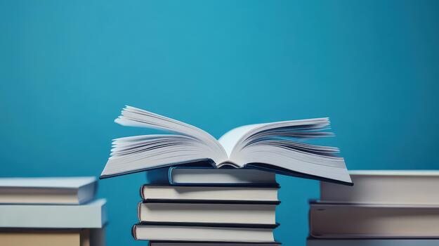 Open Book Rests Atop Stack of Books Against Blue Background photo