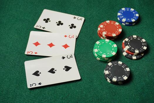 Chips are scattered around, and the three cards are a mix of suits and values, indicating active bets and future winnings photo