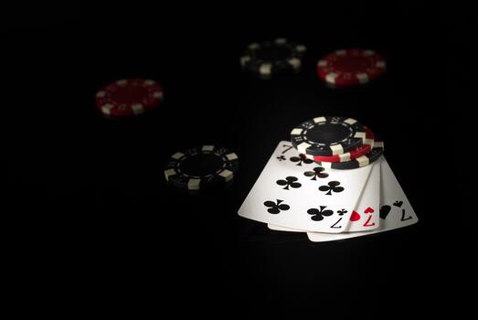 Playing cards on a black table with a winning combination three of a kind or set in game poker and chips in the background. photo
