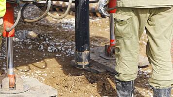 Close-up of soil sampling during pile drilling process. Extraction of subsurface material for geotechnical analysis and foundation assessment. High quality 4k footage video