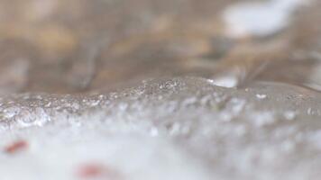 närbild av bubblande vatten med isliknande textur, skapande en fängslande visuell video