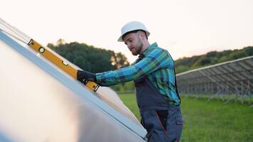 tekniker montera sol- paneler använder sig av utjämning verktyg video