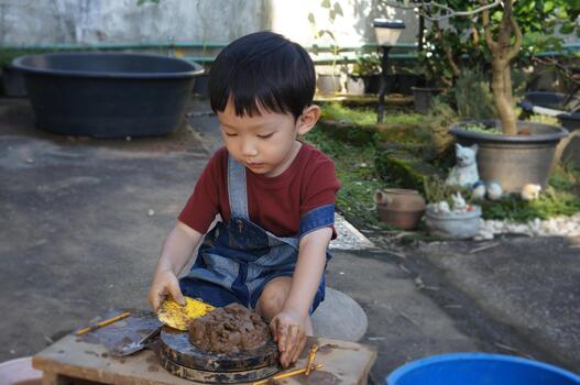 The Asian Child Intently Playing and Exploring with Clay photo