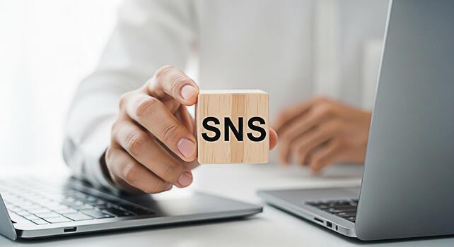 Closeup of a person holding a wooden block with the letters SNS in a bright office environment symbolizing social networking services and modern communication technologies photo